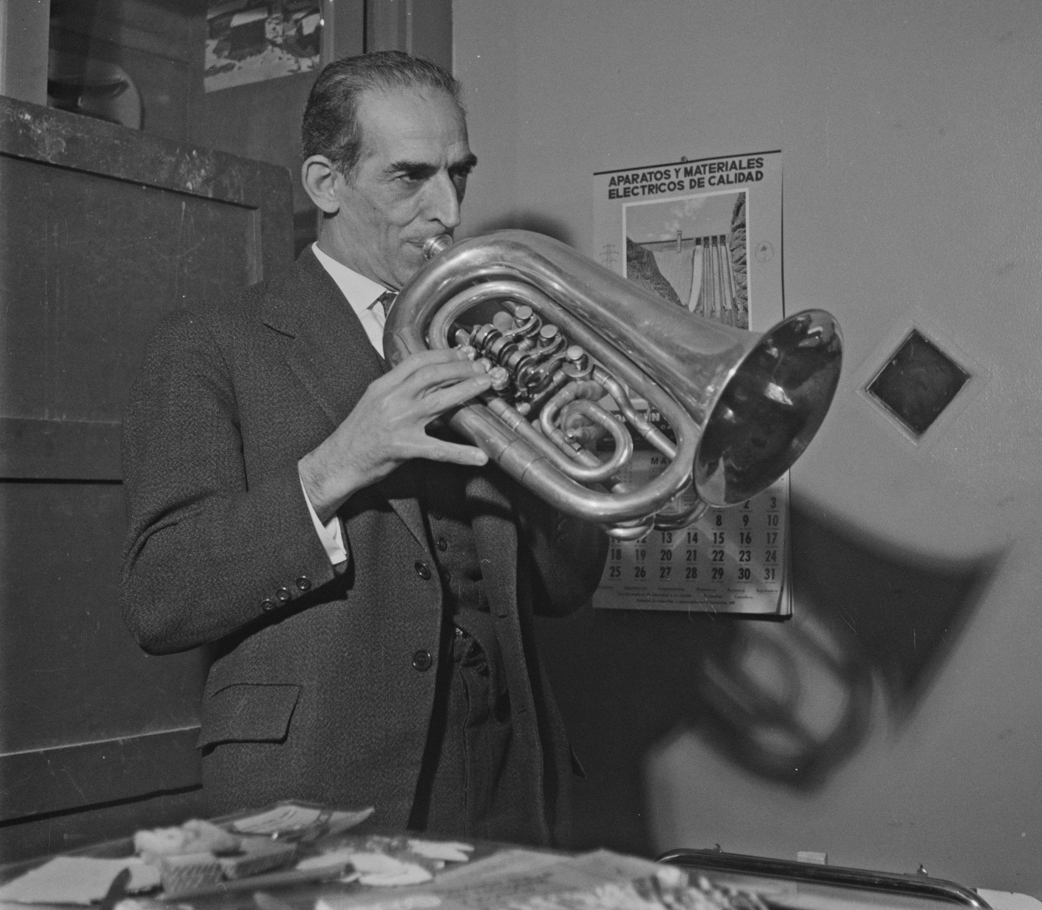 Conrad Salo joue du fiscorn dans l'atelier de Fidel Pardo, horloger et facteur des instruments de la cobla catalane à La Bisbal d'Empordà (Espagne, Catalogne), 7 avril 1963 (cliché Pierre Soulier, Mucem Ph.1963.168.054)