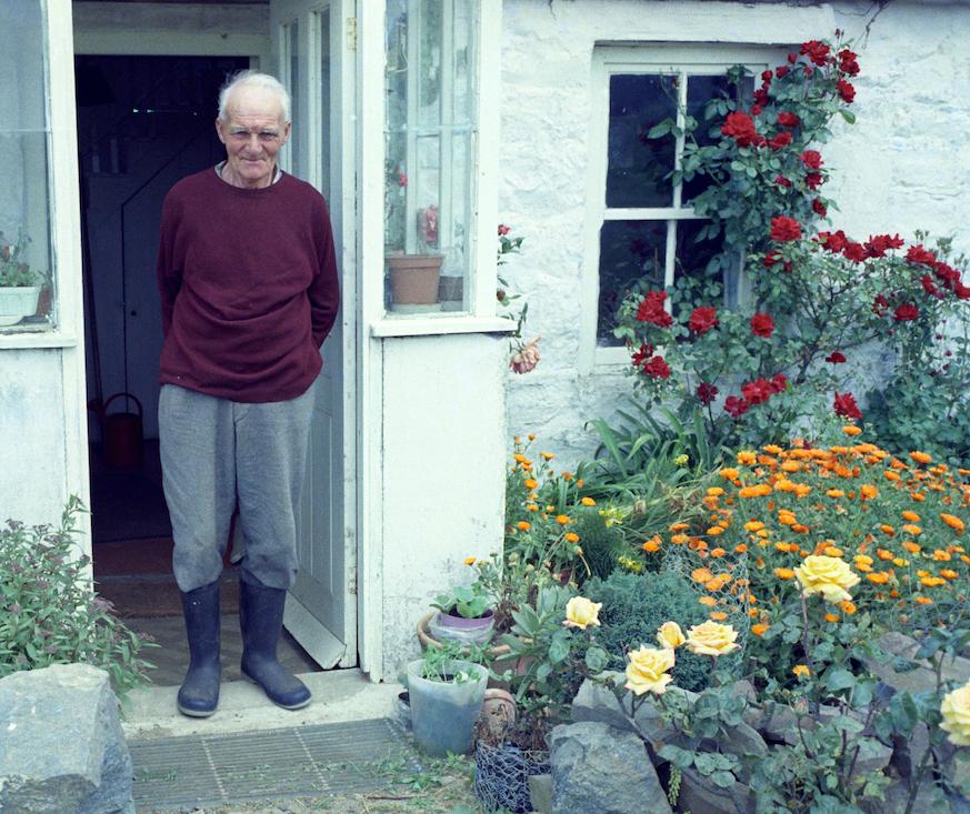 Jack Le Feuvre sur le seuil de sa maison en 1970, La Genetiere, Sercq, îles anglo-normandes ( (cliché Maguy Andral, Mucem, Ph.1972.158.2)