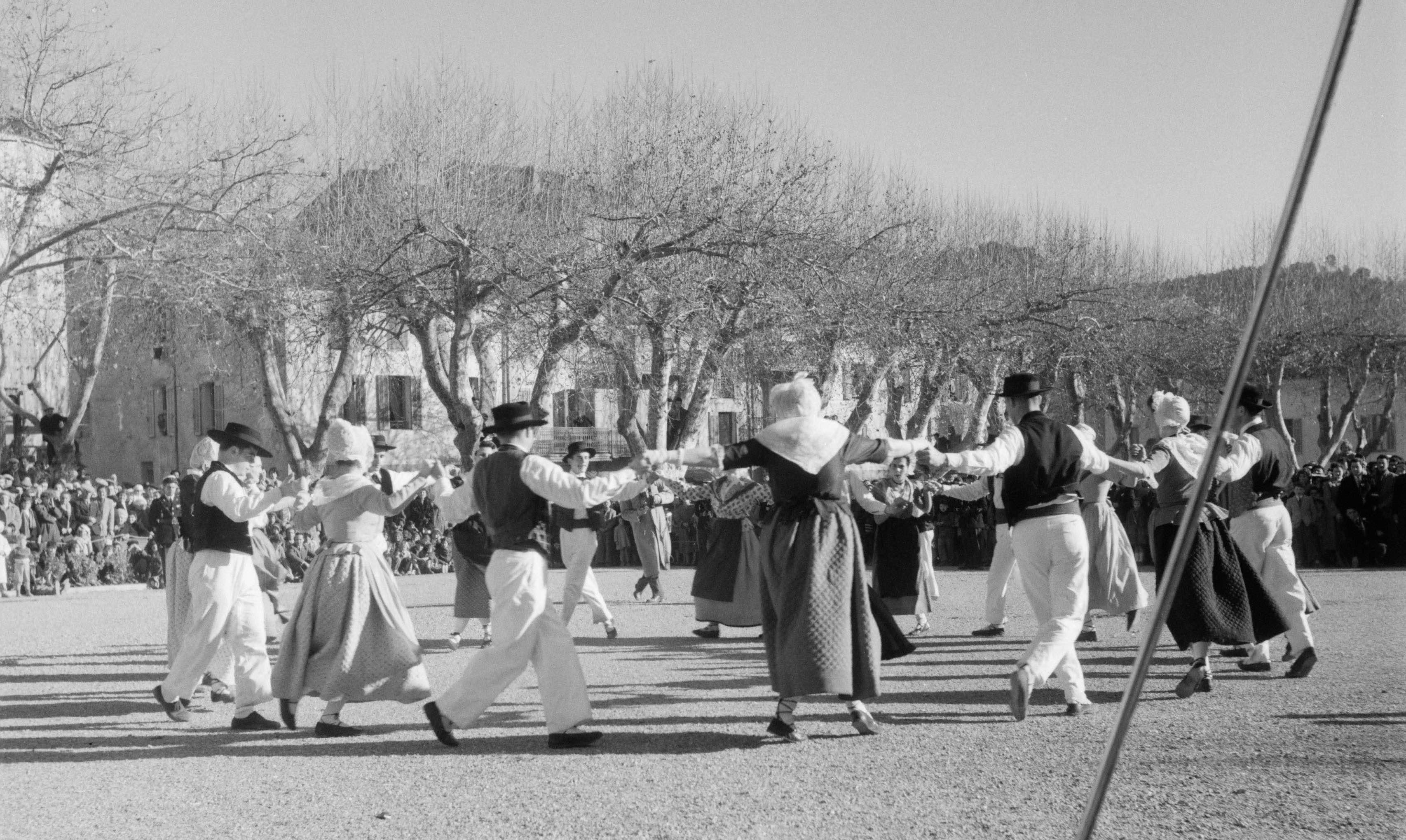 Barjols (Var), 17 janvier 1954: pendant la fête patronale de la Saint-Marcel, le groupe folklorique toulonnais "L’escolo de la Targo" danse une montagnarde sur la place de la Rouguière (cliché Pierre Soulier, Ph.1954.017.072)